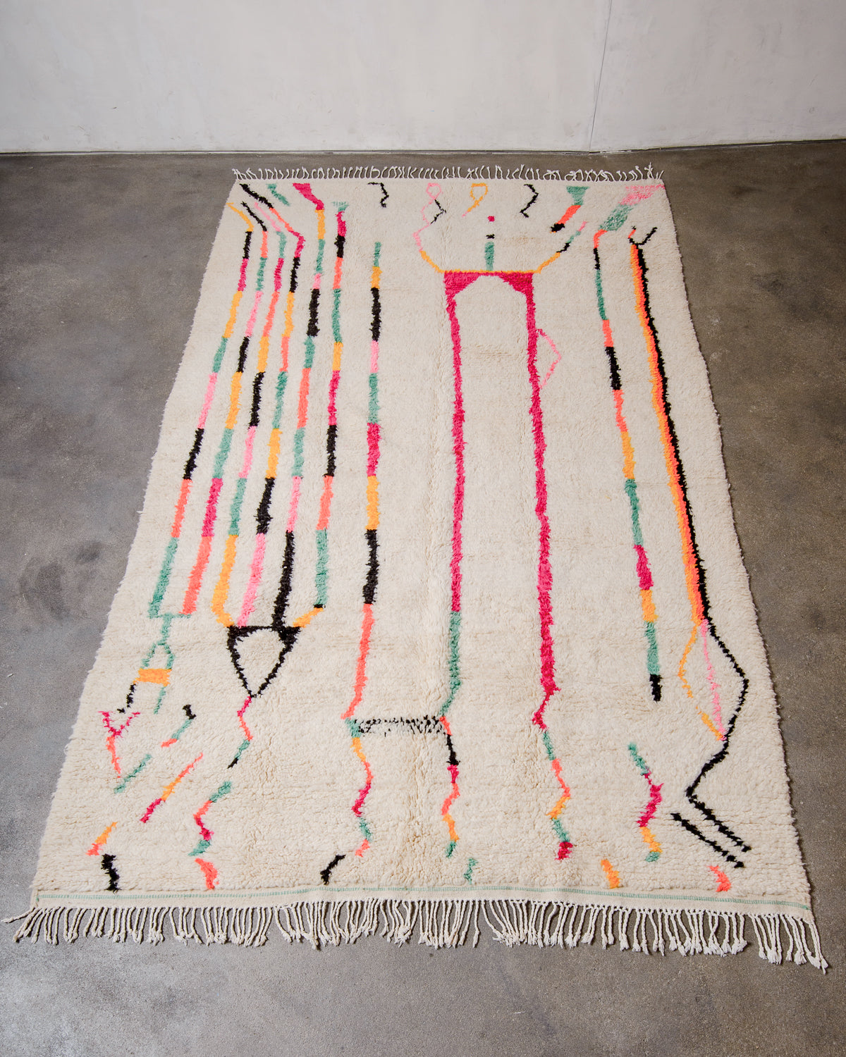 Berberlin Azilal rug made of fluffy wool and cotton, laying flat on a concrete floor.